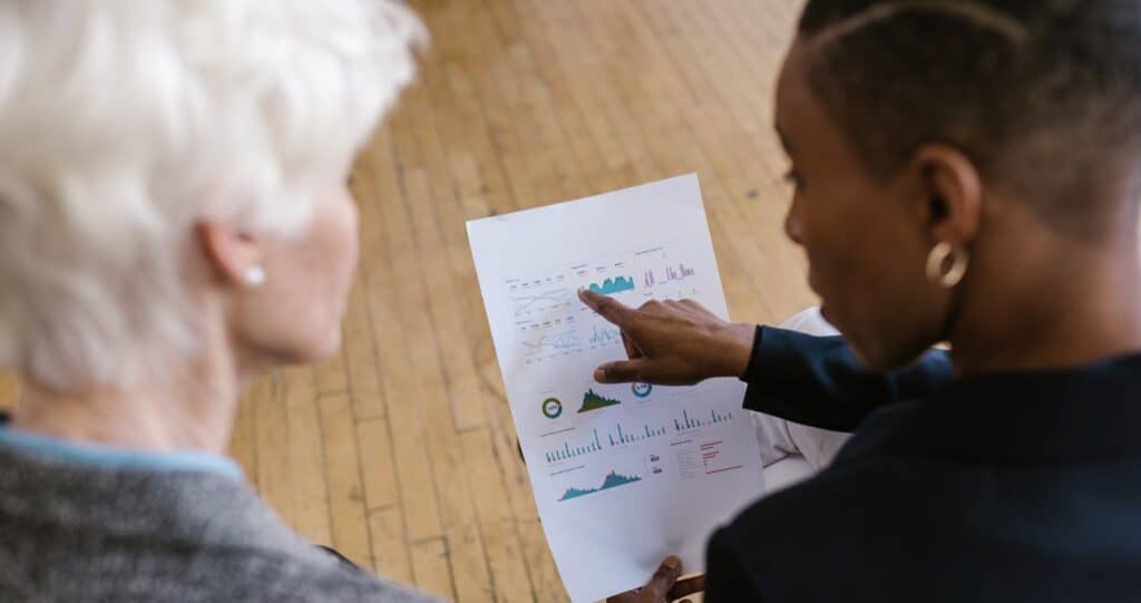 A photo of two people reviewing their crowdfunding goals and performance indicator chart.